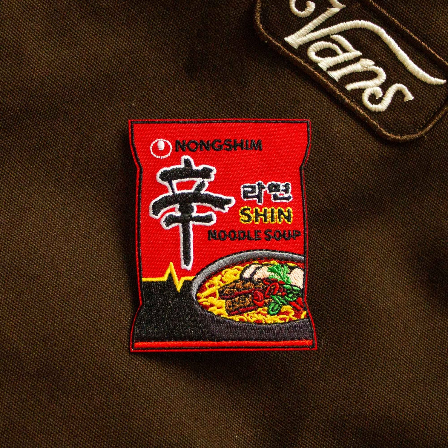 An iron-on patch of the Korean noodle brand, Shin Ramen.