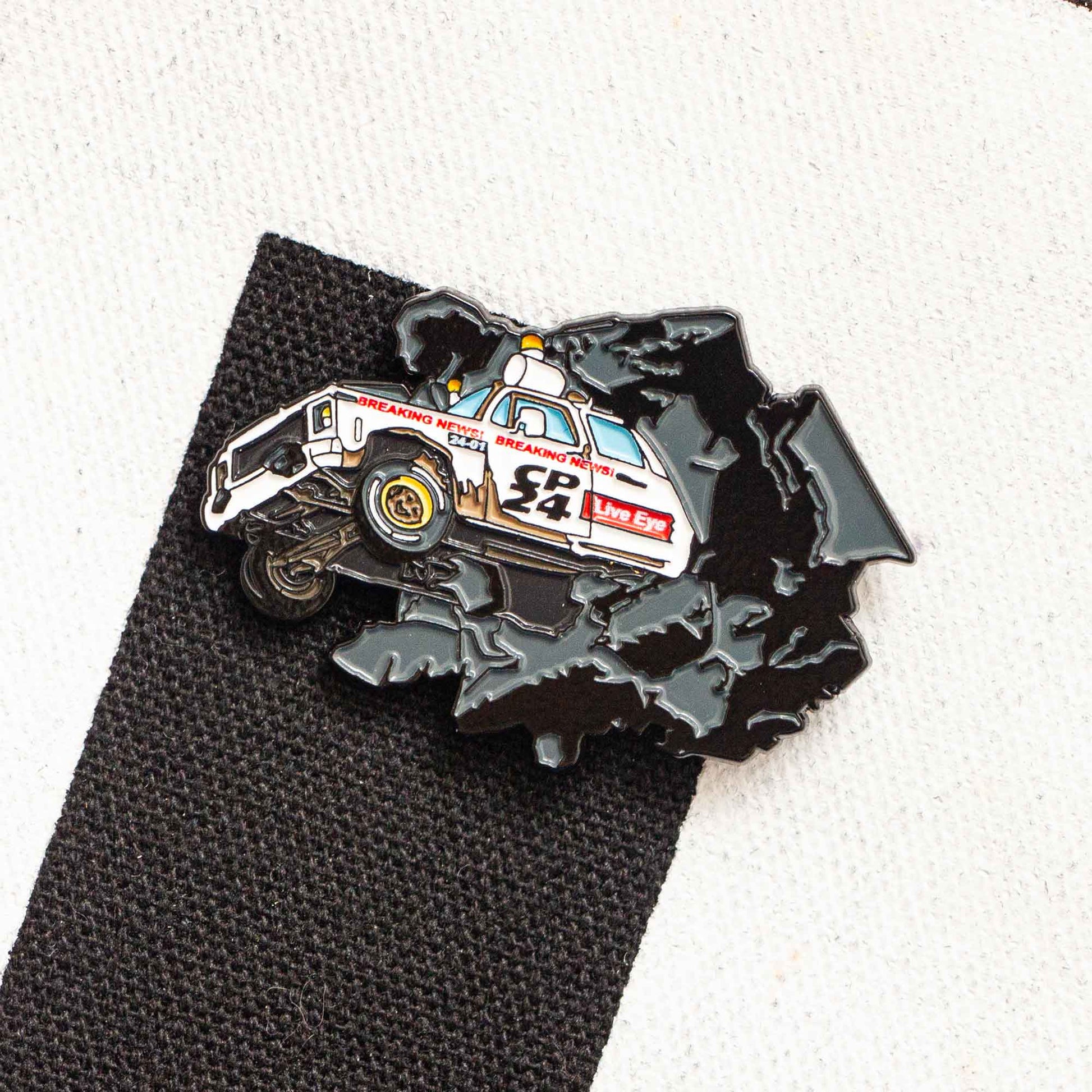 An enamel pin of the CP24 truck smashing through the wall of the CHUM-City building.