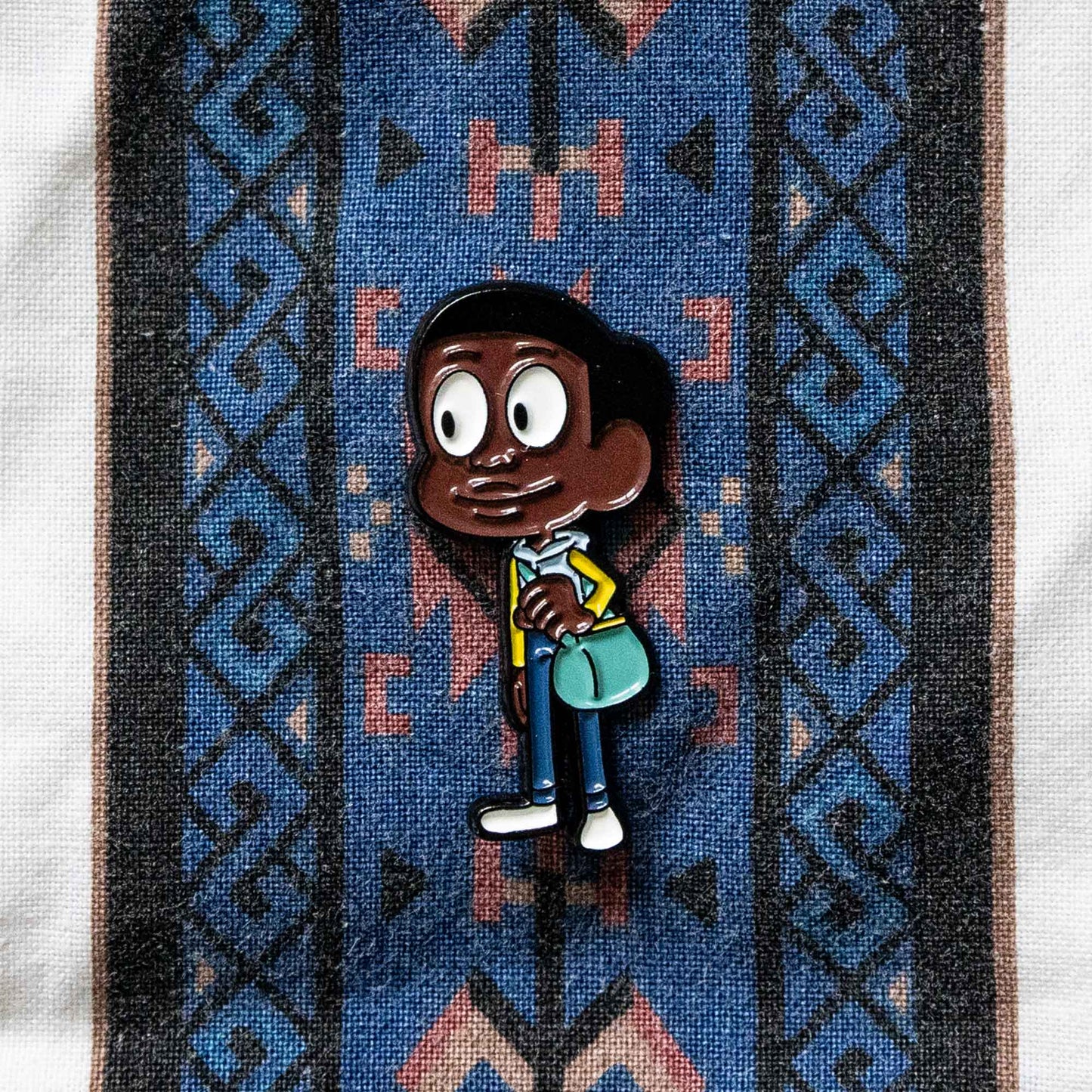 A soft enamel pin of Craig, from the animated series, Craig of the Creek.