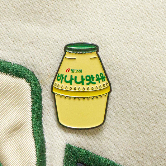 An enamel pin of a Korean banana milk.