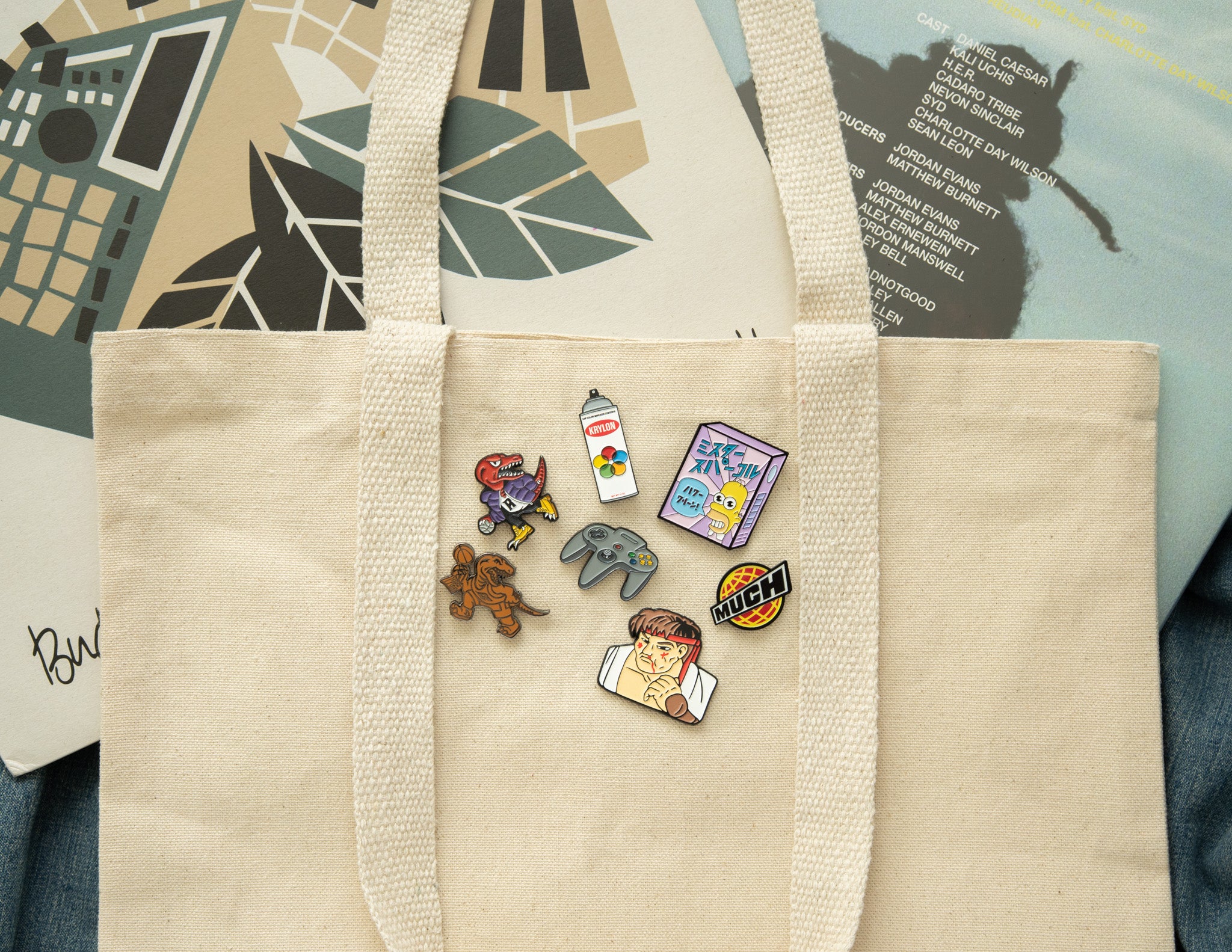 A collection of enamel pins pinned on a tote bag.