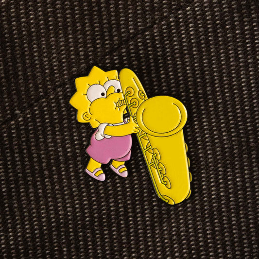 A soft enamel pin design of Baby Lisa from the animated cartoon series, The Simpsons. She is playing a big saxophone.