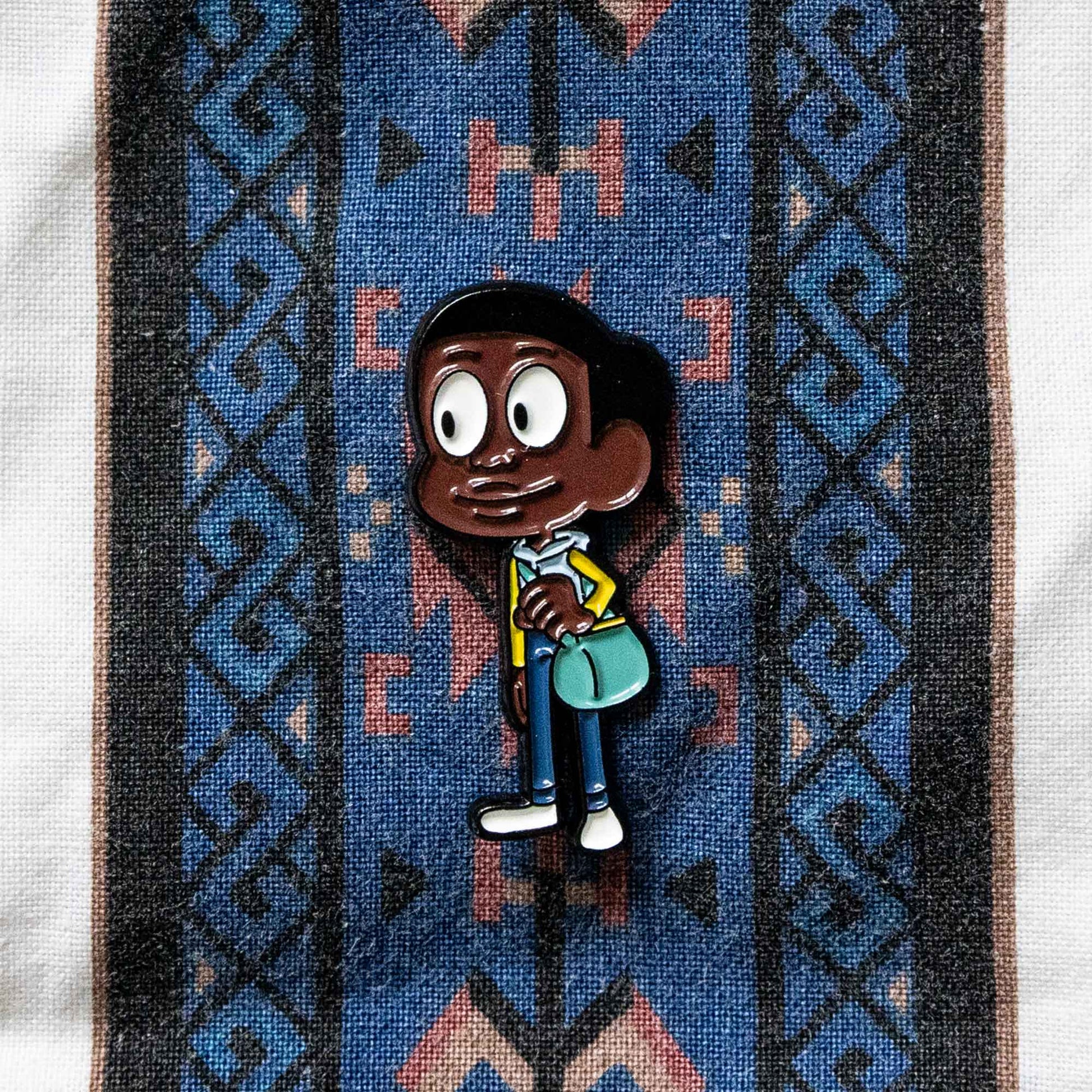 A soft enamel pin of Craig, from the animated series, Craig of the Creek.