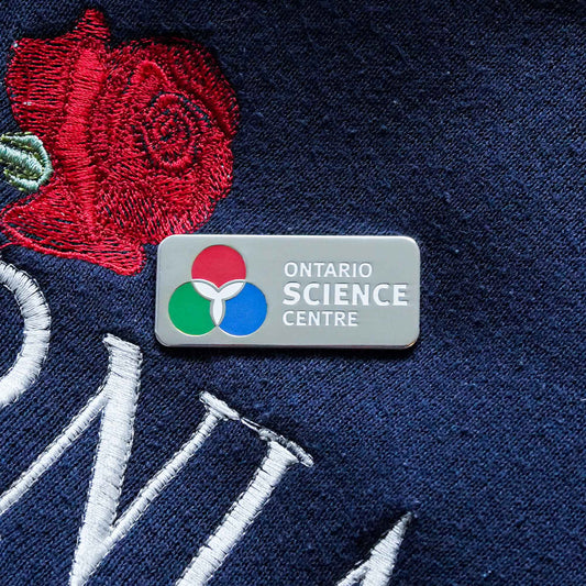 A hard enamel pin design of the Ontario Science Centre logo.