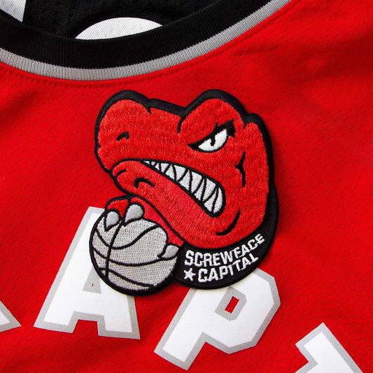 An iron-on patch of the Toronto Raptors mascot mean mugging.